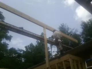 Carpenter setting a ridge beam over a new addition frame — Ice Dam Removal by Roofing Brothers in Jelm