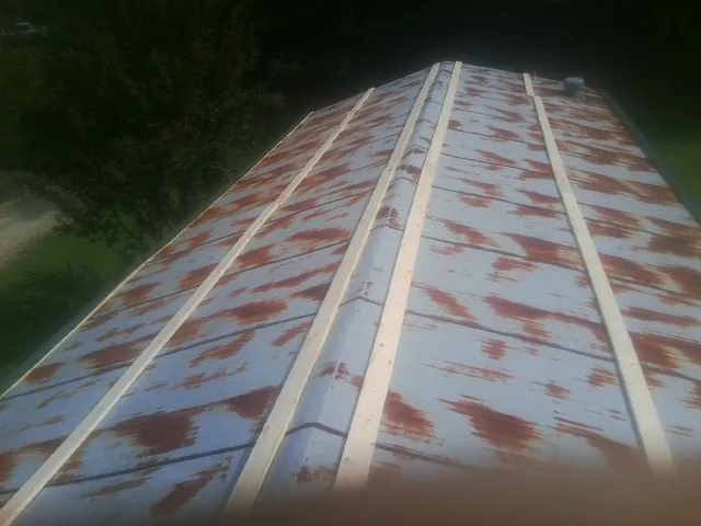 Rusted metal roof panels with new wood purlins before replacement — Storm Damage Roof Repair in Jelm by Roofing Brothers